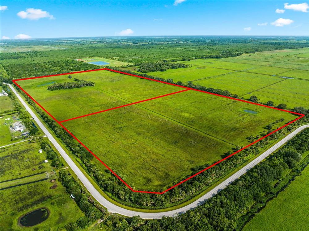Aerial view of an undeveloped agricultural parcel with its boundary outlined in red