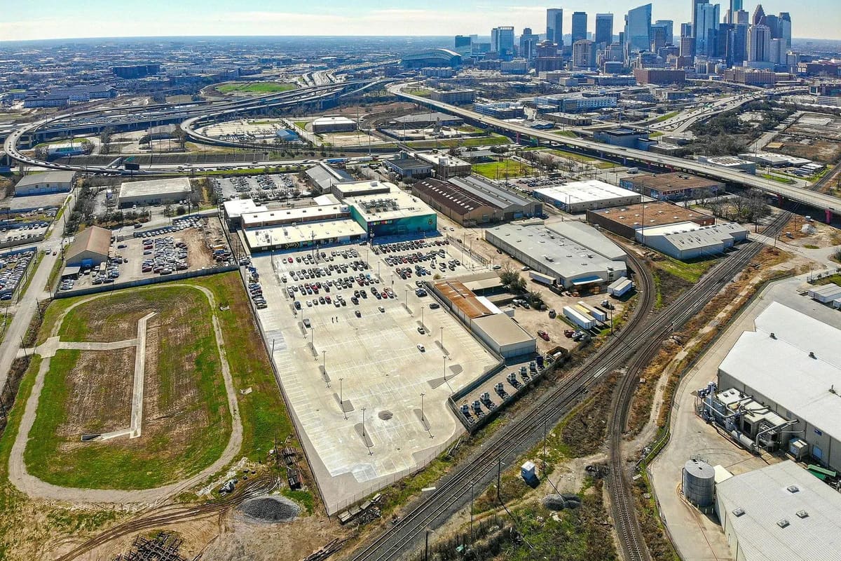 An aerial view of an industrial district beside a city skyline
